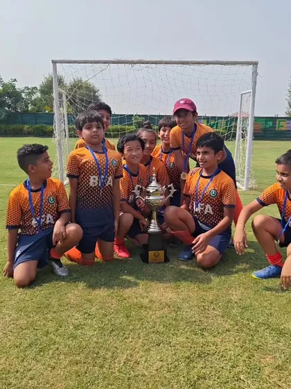 The victorious team posing with their trophy on the field. A memory of a great day and a great performance.