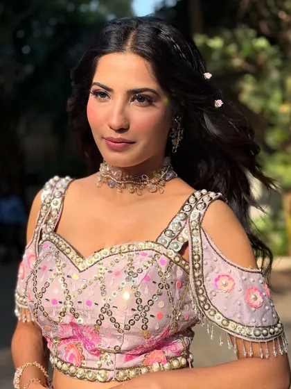 A dreamy look for a Mehendi carnival. The soft, romantic waves are adorned with tiny flowers, and the rose-toned makeup gives a beautiful, healthy flush to the skin.