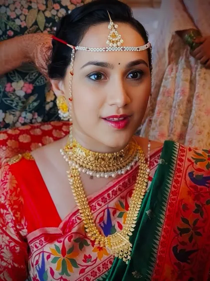 A close-up of a beautiful Maharashtrian bride. We focused on traditional details, including the placement of the 'mundavalya' (forehead ornament) and a classic makeup look with a bindi and radiant skin.