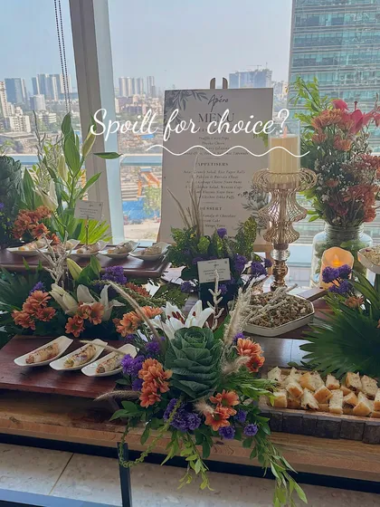 Spoil your guests for choice with a lavish spread that has something for everyone. This table is overflowing with appetizers, cheeses, dips, and fresh flowers, creating an inviting and abundant feel.