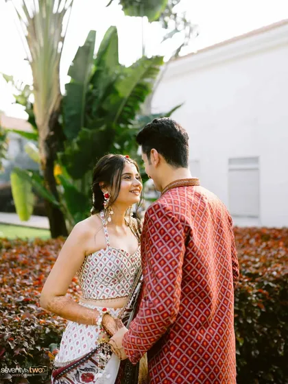 A sweet portrait of the couple in Goa, their vibrant outfits contrasting beautifully with the lush green surroundings of the resort.