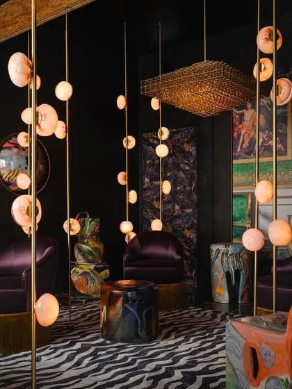 A wider view of the Bocci 84 installation, where multiple columns create a forest of light. This series blends glass and metal in a unique way, revealing delicate copper-hued pillows when lit.