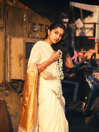 Finding a moment of peace on a busy street corner, with a traditional gajra in hand. The golden hour light adds a warm glow to this street portrait.
