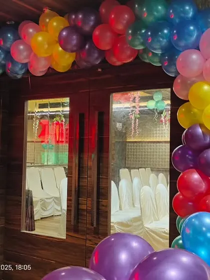 A colorful balloon arch in primary colors at the entrance of a princess-themed first birthday party.