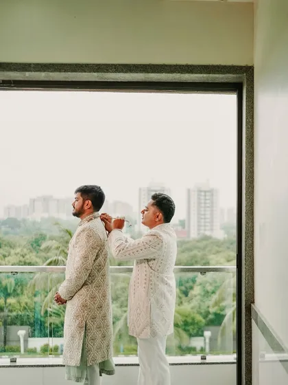 A father helping his son get ready. This quiet, supportive moment between father and son on the wedding day is a beautiful and often overlooked part of the story.