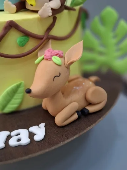 The sleeping deer, a peaceful addition to the vibrant jungle cake.