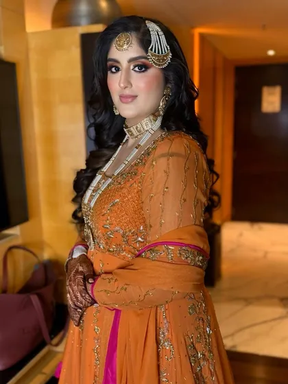 A front view of the royal bridal look, with voluminous waves and a statement passa.