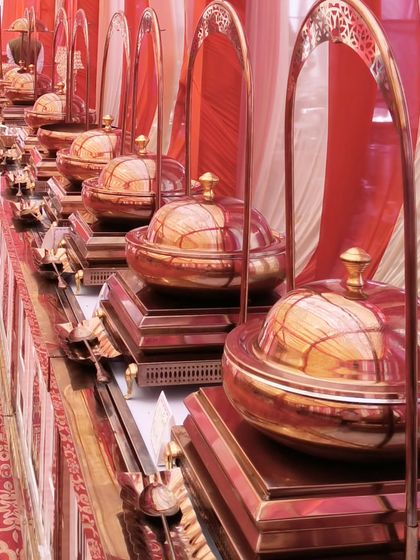 A close-up of our signature copper-domed chafing dishes, which are a key element of our traditional wedding catering setups. They reflect our commitment to authentic and elegant presentation.