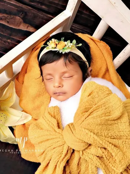 This angle shows the full setup, with the baby looking like they are sleeping in a field of flowers.