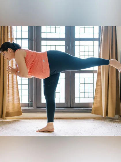 This is me practicing a modified Warrior III (Virabhadrasana III) during my pregnancy. Balancing poses were my favorite for maintaining mental focus and physical stability. My personal practice informs everything I teach.