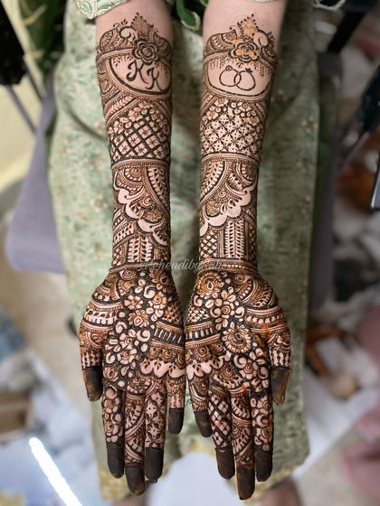 A closer look at a personalized bridal design. I incorporated the couple's initials "KK" and a symbol of two rings, surrounded by classic floral and geometric patterns that cover the hands and forearms.