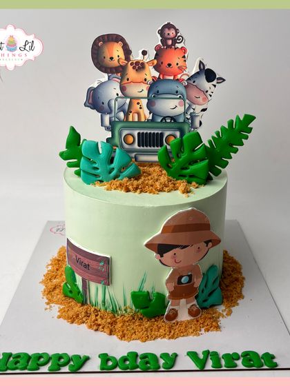 A sweet safari adventure for Virat's birthday. This cake features a little explorer and a jeep full of cute jungle animals, set against a sandy, crumb-covered landscape.