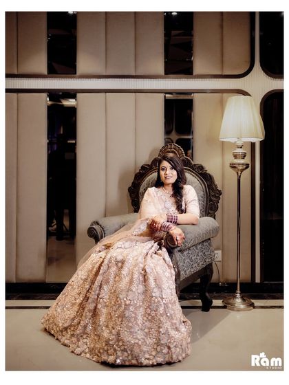 A regal portrait of the bride seated on an ornate throne-like chair, her lehenga spread beautifully around her. This shot exudes elegance and sophistication.