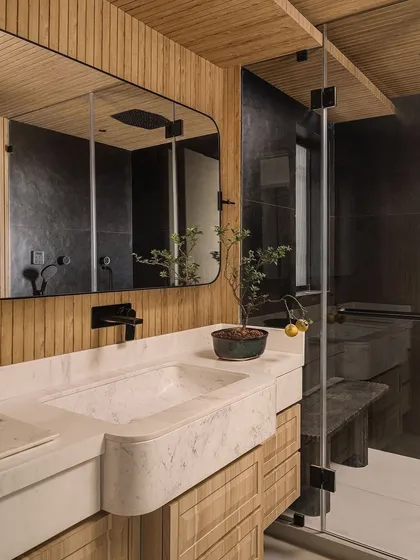 Another bathroom from our portfolio, featuring a custom marble vanity and wood-paneled walls. The design creates a warm, natural, and spa-like feeling.