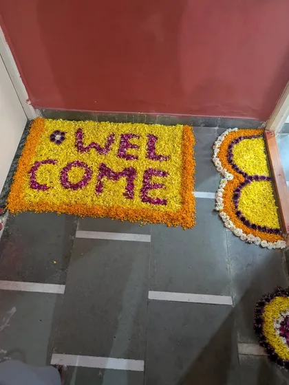 A traditional and heartfelt welcome begins at the doorstep. We crafted this "WELCOME" message using yellow, orange, and purple flower petals to create a beautiful floral mat.
