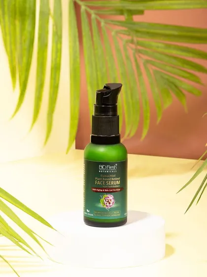 A shot of Biofresh Botanicals' face serum on a white pedestal, framed by palm leaves. This styling gives the product a fresh, tropical, and rejuvenating feel.