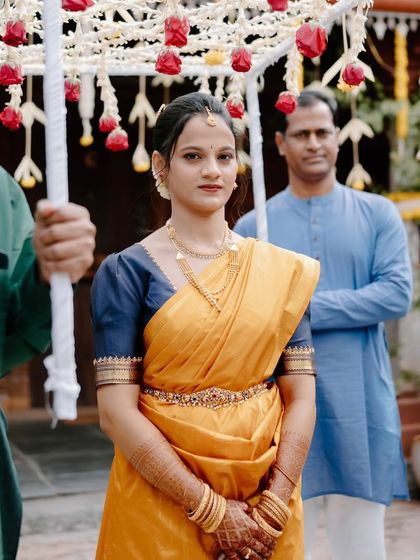 A candid moment as the bride enters her engagement ceremony. Her makeup is flawless and her expression is serene, ready for the rituals ahead.