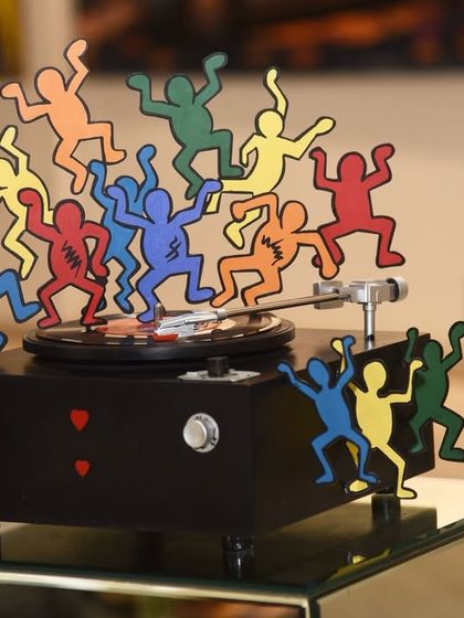 "The Beat Goes On" is a bold homage to '80s pop art and music. This metallic installation reimagines a record player as a dance floor for Keith Haring-inspired figures, celebrating motion and joy.
