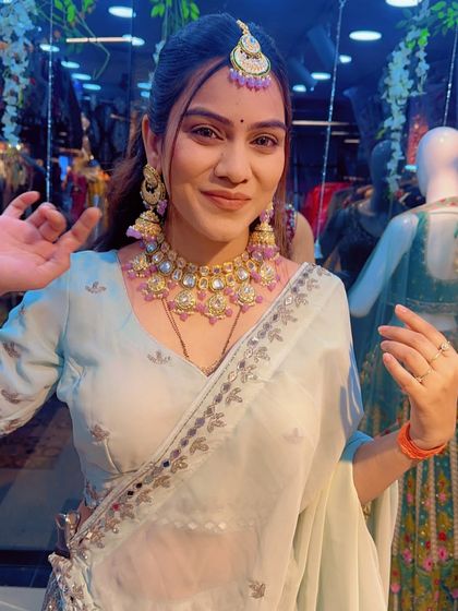 A smiling portrait of the model wearing the sea-green lehenga and lilac jewellery set, a unique and stunning choice for a Sangeet.