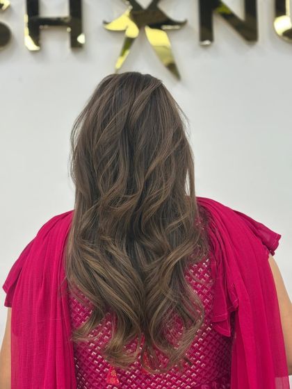 The back view of the toned highlights, showcasing the long layers and beautiful color work.