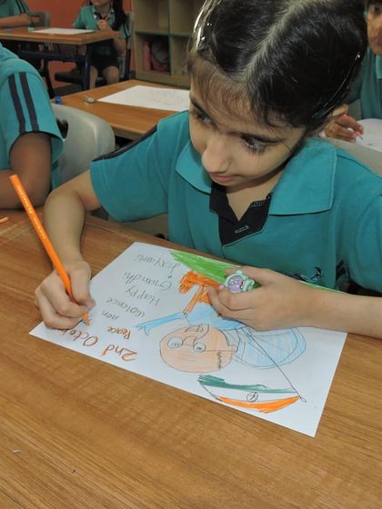 A student colors a portrait of Mahatma Gandhi, learning about the national hero through a creative and engaging activity.