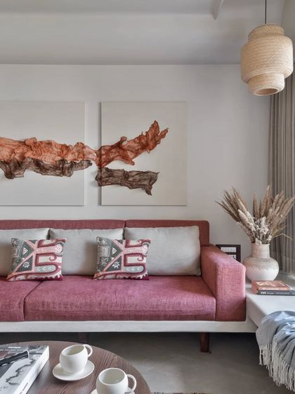 This living room uses warm-toned neutrals and pops of color in the artwork and cushions. It’s a minimalist aesthetic that still feels warm and personal.