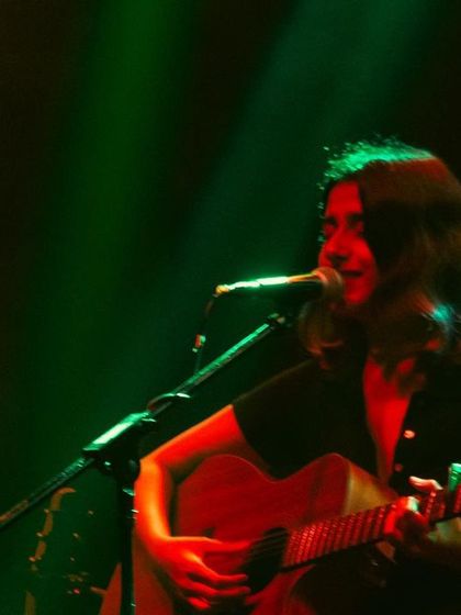 A different perspective of our trio, with green stage lights creating a cool, moody atmosphere.