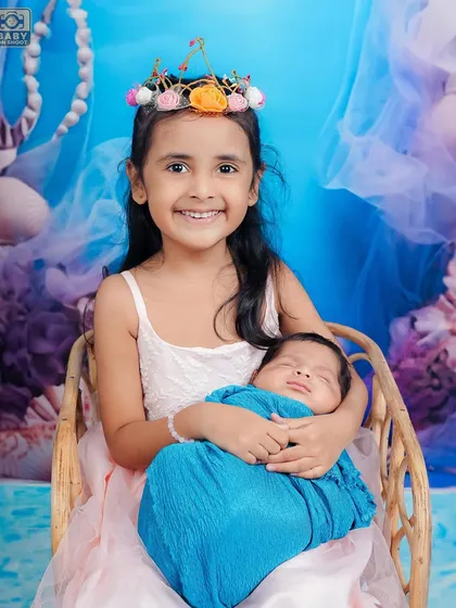 Capturing the bond between siblings is one of my favorite things to do. Here, a proud big sister holds her newborn brother, creating a truly special memory. I ensure these newborn and sibling photoshoots are always safe and gentle.