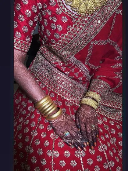 A full view of the bridal lehenga with the beautifully stained hands, a complete and regal look.