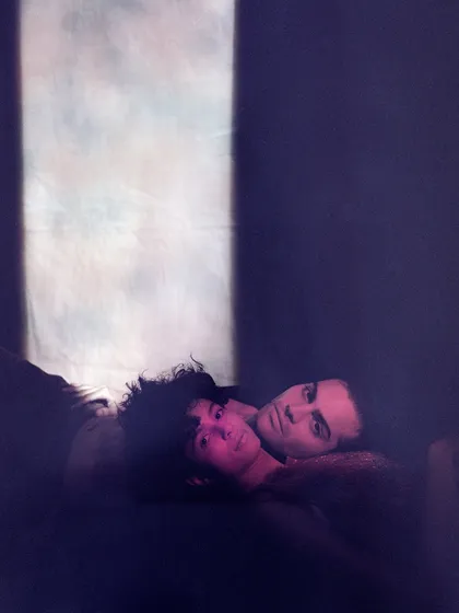 A soft, dreamlike portrait of two models from an archival shoot. The purple tones and hazy light create a romantic and intimate atmosphere, showcasing a different side of my creative direction.