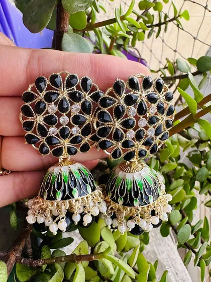 A timeless black meenakari jhumka. The black enamel is contrasted with green details on the dome and small white pearls, making it a sophisticated choice for evening events.