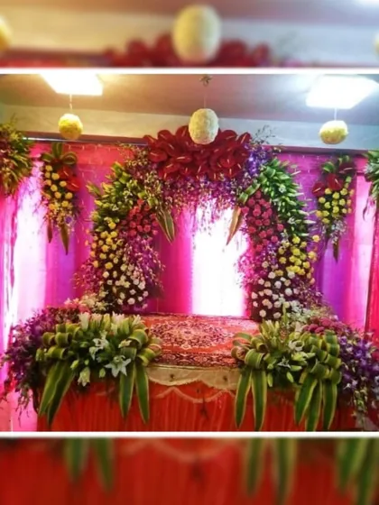 This is a rich and colorful floral arch designed for a Ganpati mandap. The combination of deep pink fabric, vibrant flowers, and hanging bouquets creates a grand and festive atmosphere for the celebration.