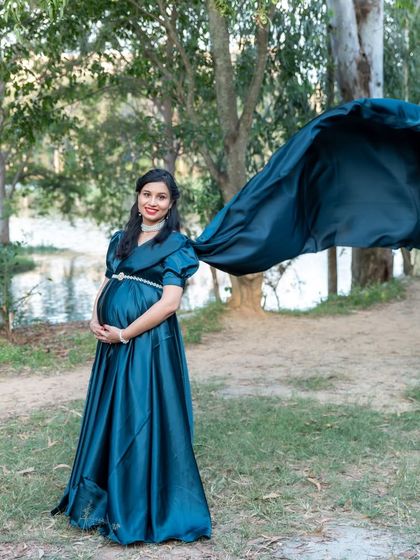 The deep teal of this satin gown looks incredible against the natural lakeside scenery. The wind catching the train of the dress adds a perfect touch of drama to this outdoor maternity photo.