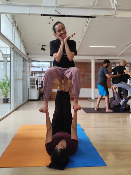 A moment of playful connection and balance during our acro yoga session. The base provides a solid foundation, allowing the flyer to sit with ease and grace. This is what building trust through movement looks like.