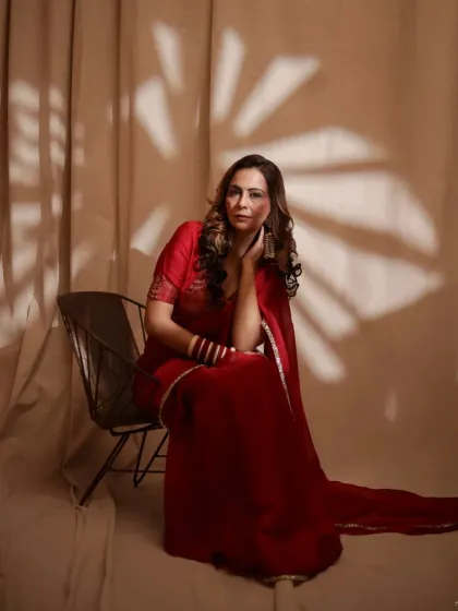 Another look from our red saree series, this time playing with patterned light. The shadow of the leaves adds a layer of visual interest, creating a unique and artistic fashion portrait.