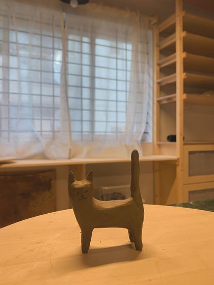 A small, hand-sculpted cat figure, standing proudly in my studio. This piece, which I call "Luna," is a reminder to find comfort and peace in your own company.