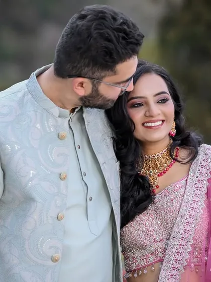 A sweet and tender moment, with the groom resting his head on the bride's shoulder.