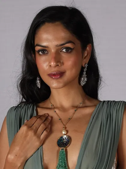 A model ready for the runway with a classic winged eyeliner and elegant jewelry. This timeless look is a staple in any professional makeup artist's skill set.
