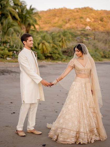 A romantic walk on the beach. The flowy silhouette of the bride's Tarun Tahiliani lehenga was perfect for this coastal wedding, allowing for beautiful, natural movement.