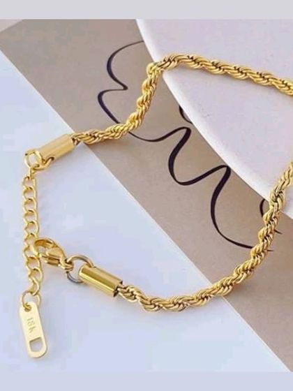 A detailed view of my gold-tone rope bracelet, showing the secure clasp and the '18K' stamp that signifies its quality plating.