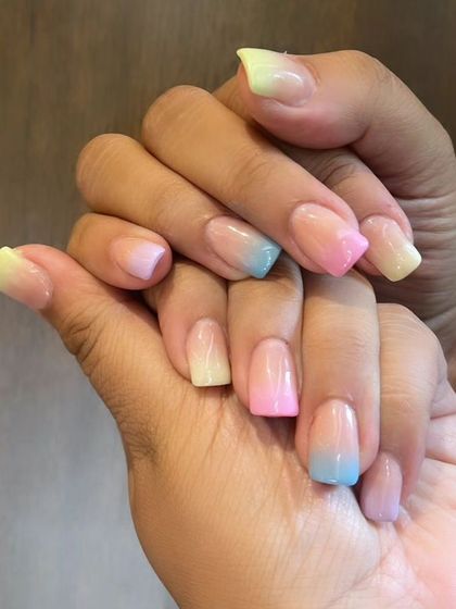 A playful pastel rainbow ombre, with each nail blending from a nude base to a different soft color like yellow, blue, and pink.