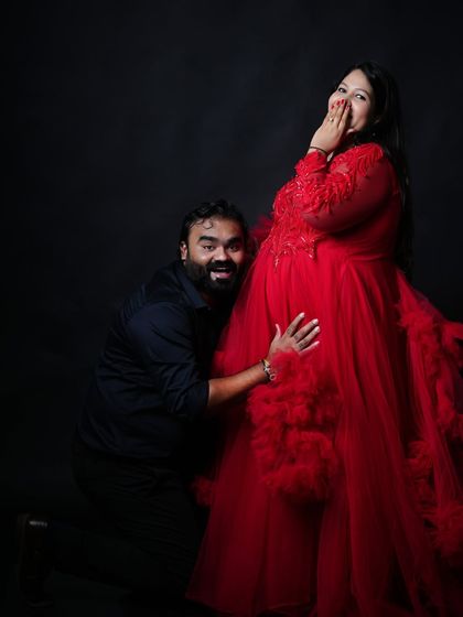 A fun and candid moment during a couple's session. The partner's playful reaction while listening to the baby bump brings a sense of joy and personality to the shoot.