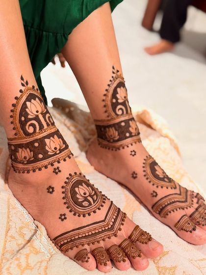 A delicate and pretty foot design for an NRI bride, featuring lotus motifs and simple ankle bands.