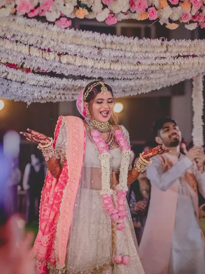 The bride dancing her way down the aisle, her happiness radiating as she approaches the mandap.