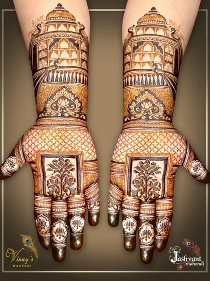 We bring the grandeur of Rajasthani palaces to your hands. This symmetrical design showcases magnificent jharokha architecture, filled with detailed lattice work and traditional motifs for a truly royal bridal look.