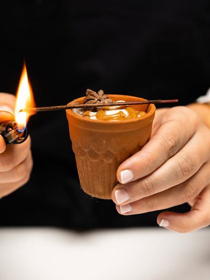 A chai-inspired dessert in a traditional kulhad, complete with a lit incense stick to evoke the aroma of Indian spices, from Chef Joanna Artieda's masterclass.