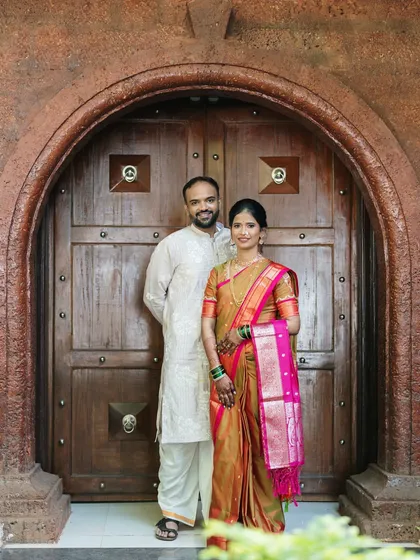 A formal portrait framed by a grand, traditional doorway. This shot combines architectural beauty with the couple's elegant presence, creating a regal image.