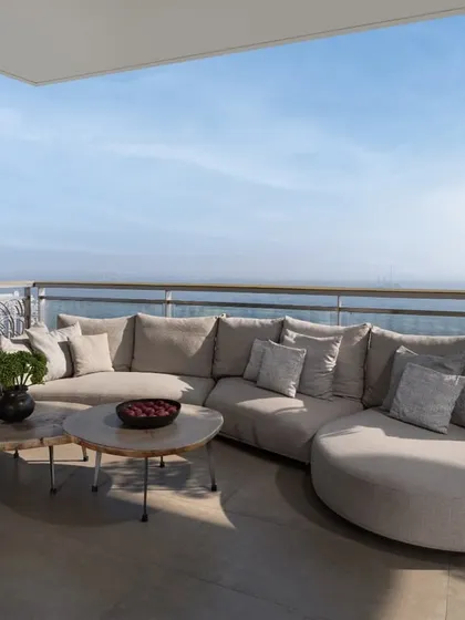 We believe in extending the living space outwards, blurring the lines between inside and out. This comfortable balcony seating area overlooks a stunning vista, creating a serene outdoor lounge that serves as a perfect urban retreat for quiet mornings or evening conversations.