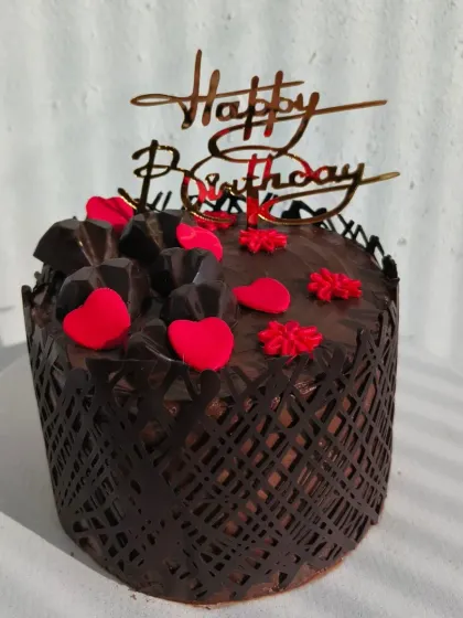 Another view of the rich chocolate cake with a decorative chocolate wrap.