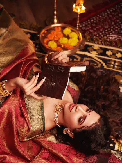 A dreamy, artistic shot capturing a moment of peace. The makeup is soft and romantic, with long, flowing hair and traditional attire creating a timeless and beautiful image.